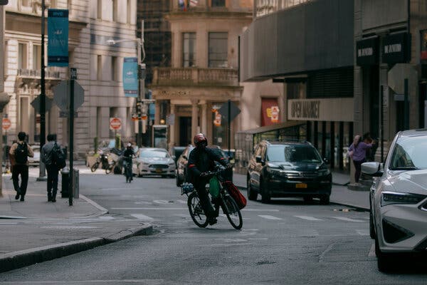 A biker rides down a city street. 